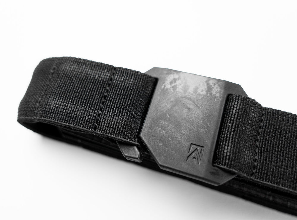 Every Day Belt close-up detail of black woven webbing and matte aluminum buckle with embossed chevron logo