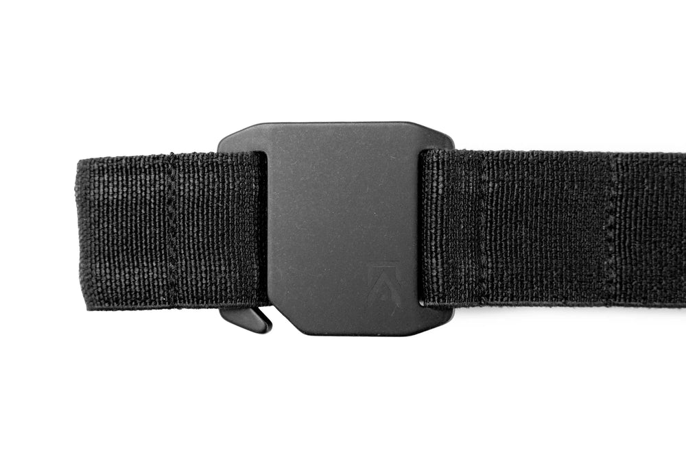 Every Day Belt close-up of matte black aluminum buckle with embossed Agonic logo on black woven webbing strap