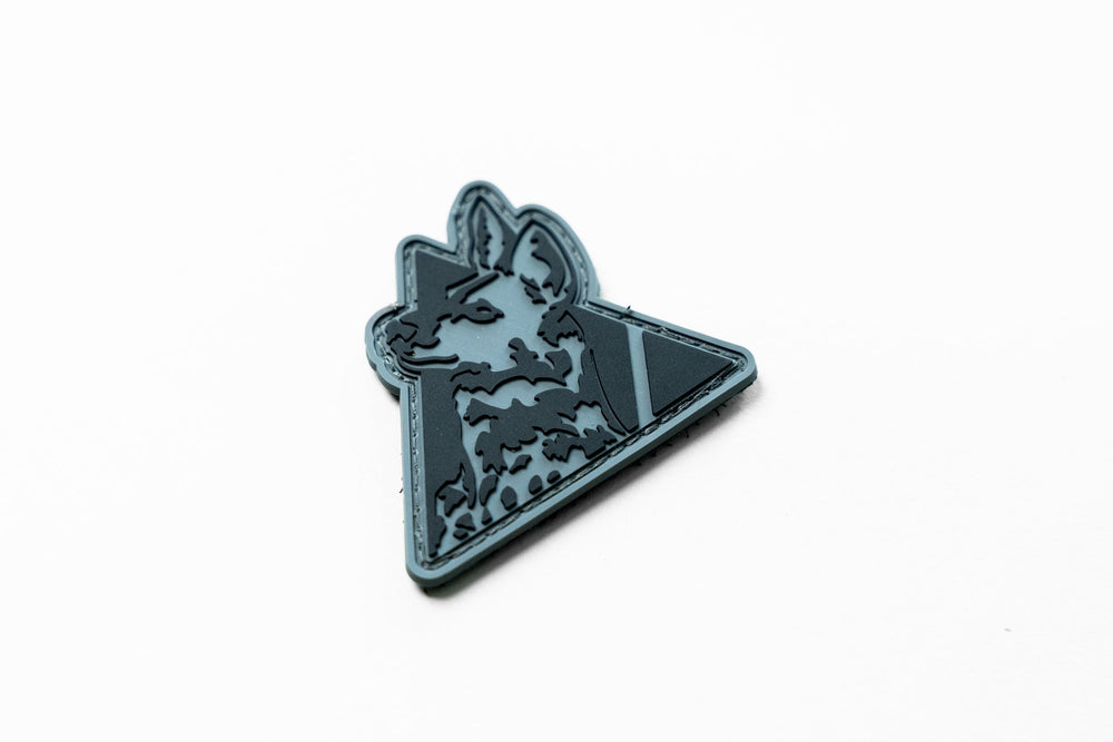 Dirty Civilian Logo Patch in gray and black PVC, triangular badge with a German shepherd head, three-quarter view