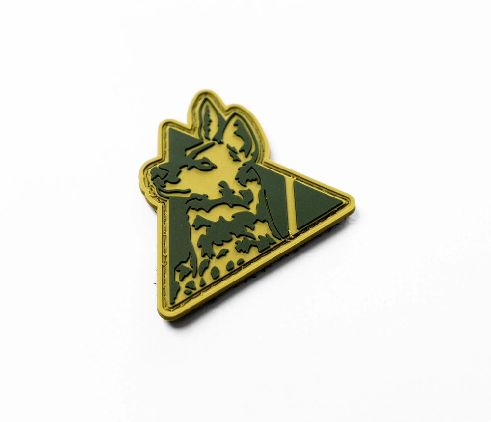 Dirty Civilian Logo Patch in olive and coyote tan PVC, three-quarter view of raised dog-head and play-triangle design