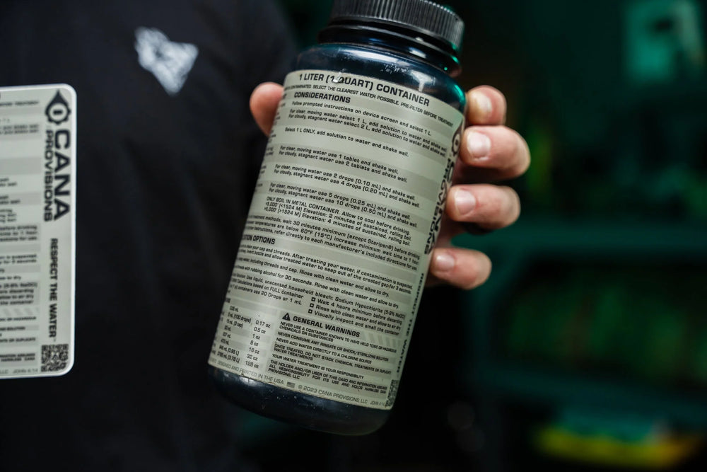 Hand holding a green Nalgene bottle wrapped in the CANA Provisions water decon decal showing treatment instructions