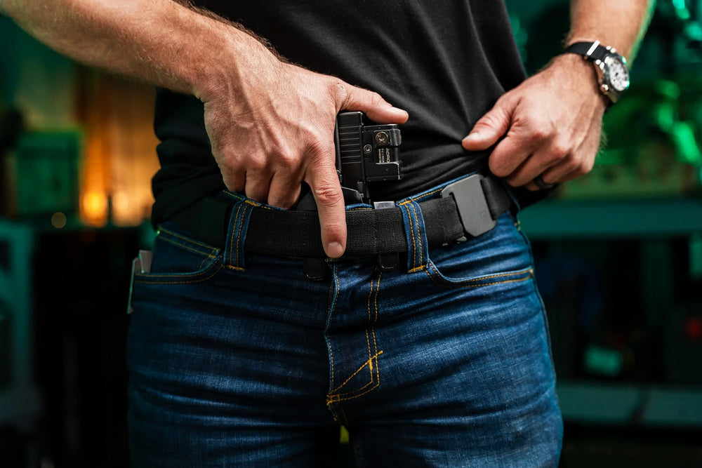 Every Day Belt worn on-body with dark jeans, black webbing and gray buckle, appendix-carrying an optic-equipped pistol