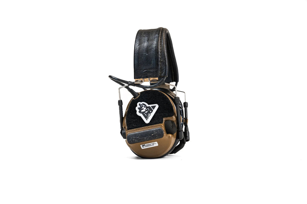 Dirty Civilian Logo Patch, triangular hook-velcro PVC with dog-head logo, mounted on coyote brown Peltor earmuff cup