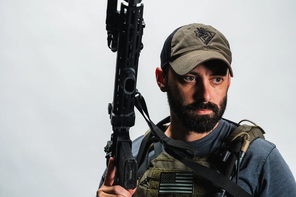 Olive green Team Cap worn by a bearded man, showing the embroidered painted dog logo, curved bill and black mesh back