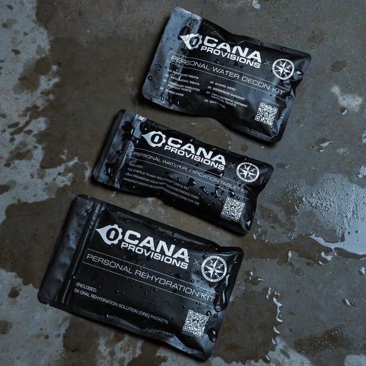 CANA Personal Decon Combo Kit: three black CANA Provisions pouches flat-lay on wet concrete—decon, purification, rehydration